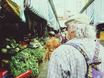 Rear view of people walking at market stall