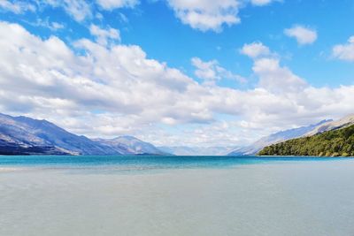 Scenic view of lake against clear sky with clouds