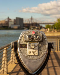 Close-up of coin-operated binoculars against cityscape