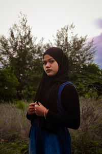 Woman standing on field against sky