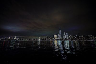 Illuminated buildings in city against sky at night
