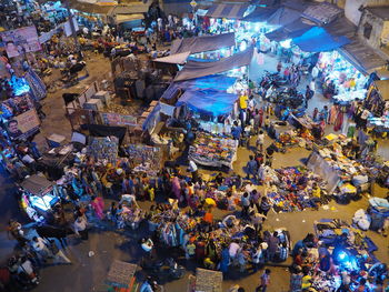 High angle view of people at illuminated bazaar during night