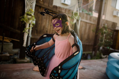 Young girl in dress up laughing and playing outdoors