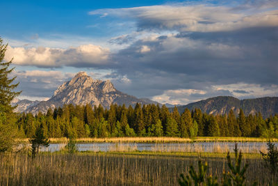 Scenic view of lake by mountains against sky