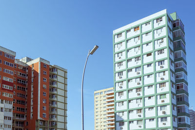 Low angle view of buildings against clear blue sky