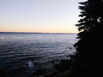 Scenic view of sea against clear sky during sunset