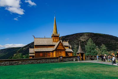 View on the medieval stave church and its fence wall, against cloudy sky on a sunny day