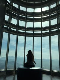 Rear view of woman sitting in petronas tower