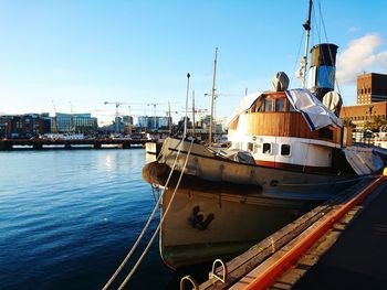 Boats moored in calm blue sea against clear sky