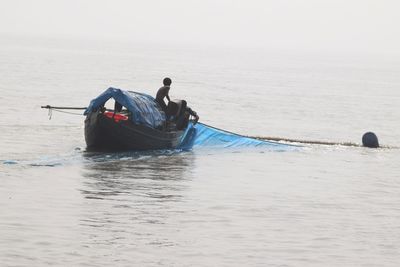 Rear view of boat in sea against sky