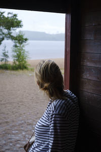 Rear view of woman looking at camera against sky
