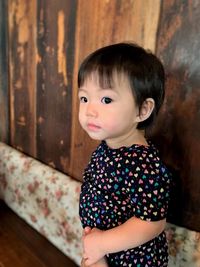 Close-up of cute girl against wall