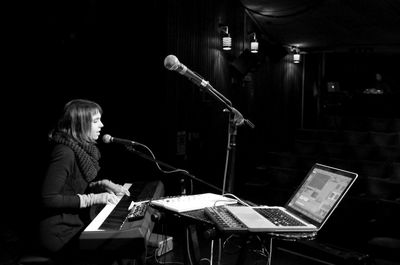 Side view of young woman singing in recording studio