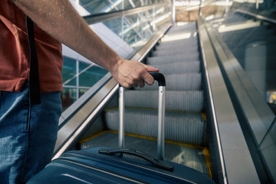 Traveling by airplane. man standing on escalator at airport. 