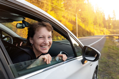 Portrait of smiling mid adult man seen through car window