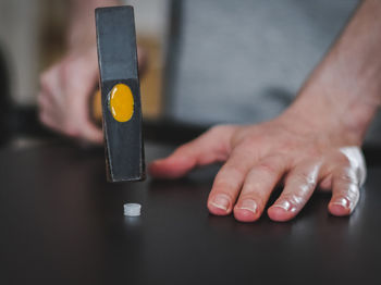 Cropped hands of man using mobile phone on table
