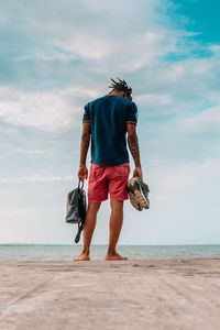 Rear view of man standing on beach