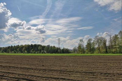 Scenic view of field against cloudy sky