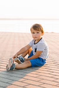 Portrait of boy sitting on floor