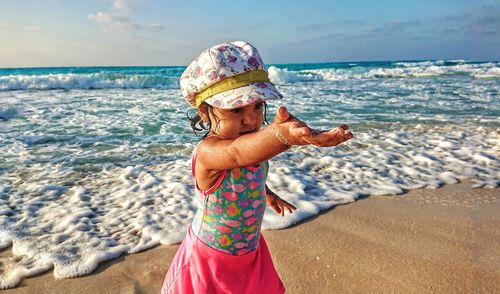 Cute girl playing on shore at beach