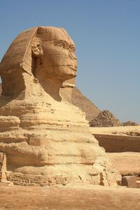 The sphinx and pyramid against clear blue sky