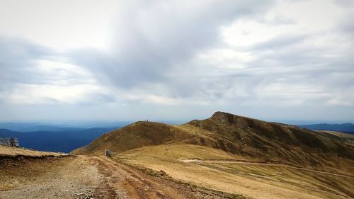 Scenic view of road leading towards mountains against sky