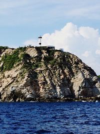 Lighthouse by sea against sky