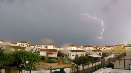 Panoramic view of residential district against storm clouds