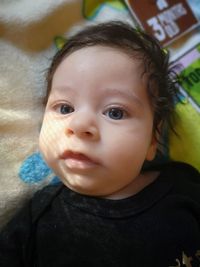 Portrait of cute baby boy on bed at home