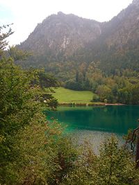 Scenic view of lake by mountains against sky