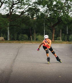 Full length of woman inline skating on road