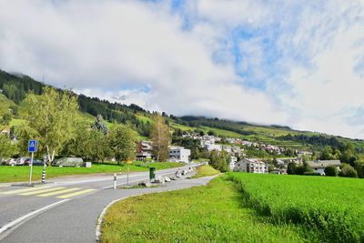 Road by trees against sky