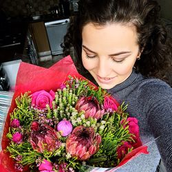 Woman holding red flowering plants