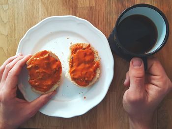 Directly above shot of hand holding breakfast on table