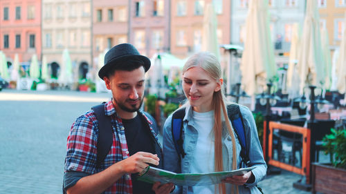 Friends using mobile phone in city