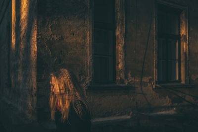 Person on window of abandoned building