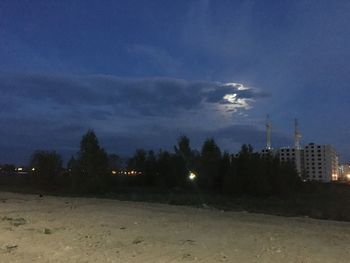 Illuminated buildings against sky at night