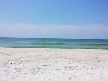 View of calm beach against blue sky