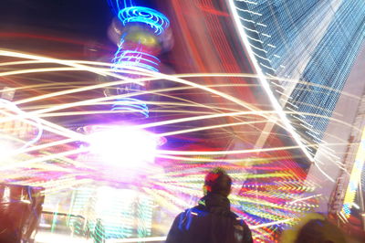 Woman in illuminated city at night