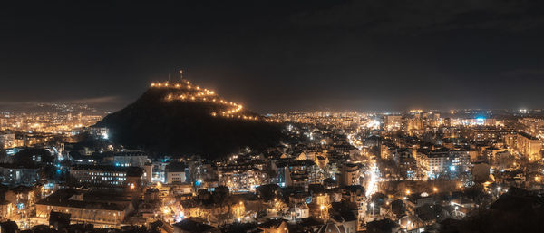 High angle view of city lit up at night