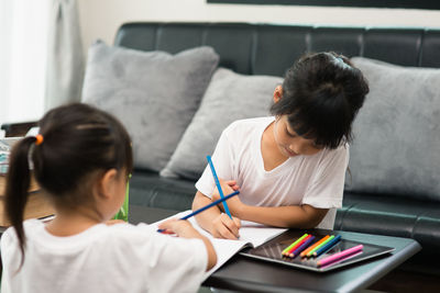 Cute siblings drawing on paper at home