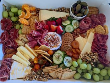 High angle view of a charcuterie board with meats, cheese and vegetables on table 