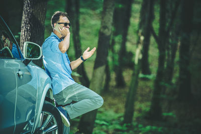 Man talking on smart phone sitting in car