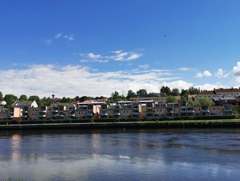 View of townscape by river against sky