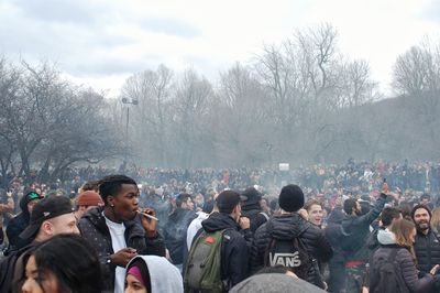 Group of people standing by bare trees in winter