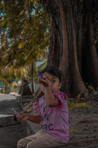 Full length of girl using mobile phone in park