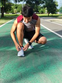 Man tying shoelace on running track