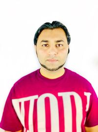 Portrait of young man standing against white background