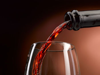 Close-up of red wine bottle against black background