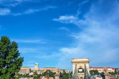 Buildings in city against blue sky